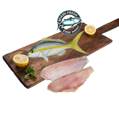 whole-fish-Yellow_tail-snapper_and-fillet-lime-on-brown-wood-plate-miami-fresh-fish-market